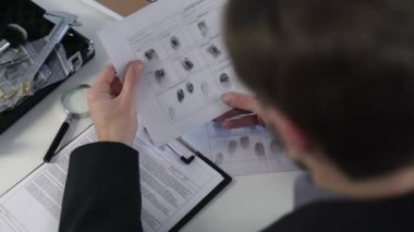 Kağıt üzerinde parmak izlerken Dedektif cinayet çözme Büyüteç, kullanarak
