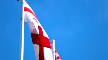 Georgia ülkenin açık mavi gökyüzü arka plan üzerinde güneşli günde sallayarak bayrak, sembol