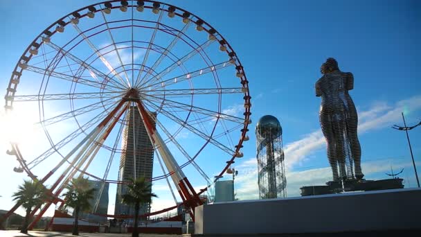 Batumi ferris roda girando perto de Ali e Nino famoso monumento e torre alfabeto — Vídeo de Stock