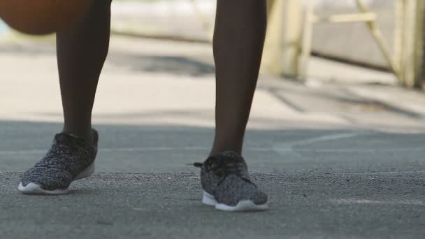 Afrikaanse man in sneakers spelen basketbal op de buiten speelplaats, oefenen — Stockvideo