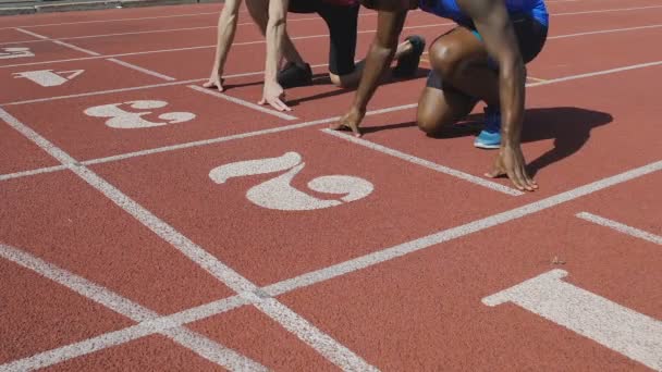 Два спортсмена на стартовой позиции готовятся к бегу, университетские соревнования — стоковое видео