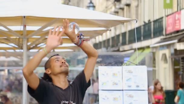LISBON, PORTUGALI - CIRCA elokuu 2014: Ihmiset kaupungissa. Street taikuri osoittaa ohikulkijoille jäähtyä suorituskykyä, ansaita rahaa elää — kuvapankkivideo