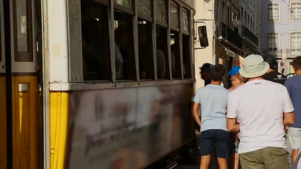 Persone stanche in attesa si girano per salire sul tram che li porterà alle loro case — Video Stock