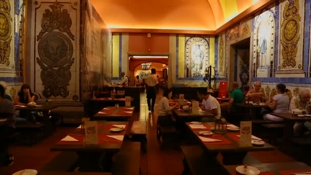 LISBOA, PORTUGAL - CIRCA AGOSTO 2014: La gente en la ciudad. Gente cenando en taberna antigua, paredes de las cuales decoradas con pinturas de mosaico — Vídeo de stock