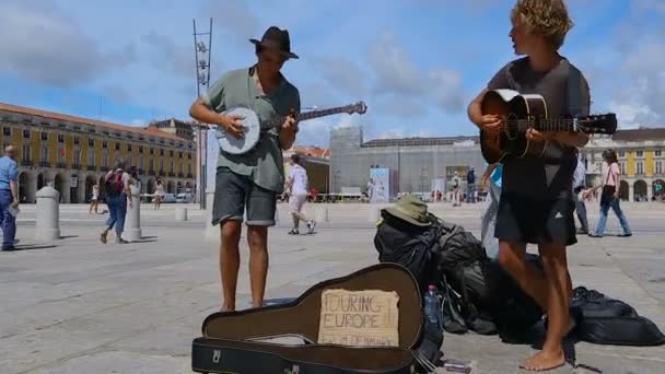 LISBOA, PORTUGAL - CIRCA AGOSTO 2014: La gente en la ciudad. Músicos callejeros tocando en medio de la Plaza del Comercio, divertidos transeúntes — Vídeos de Stock