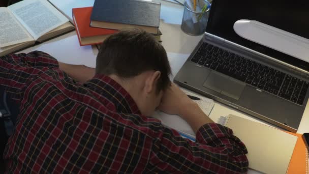 Fáradt férfi tini diák Alva rövid idő csinálás a házi feladat, iskolai fáradtság az asztalon — Stock videók