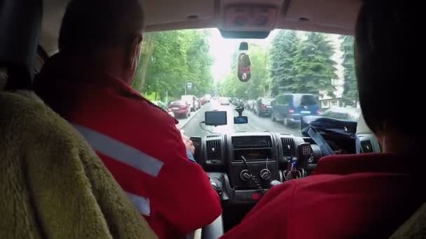 Carro de ambulância correndo ao longo da rua estreita para chamada de emergência, vista da cabine — Vídeo de Stock