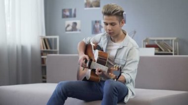 Onun yeni şarkı, yetenekli genç gitar çalmak için melodi zevk üniversiteli