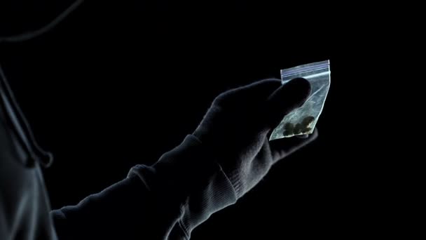 Мужская рука демонстрирует клиенту маленькую сумку с травкой, распространением наркотиков — стоковое видео