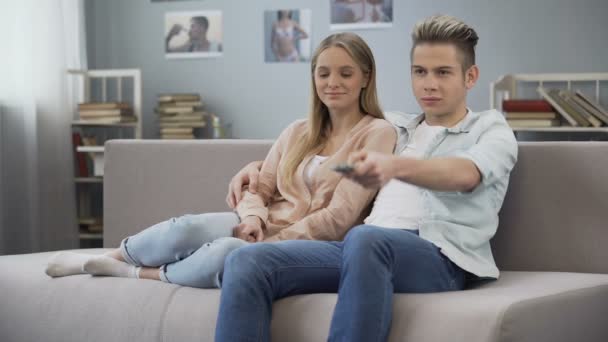 Namorado envergonhado abraçando namorada, passando tempo juntos, assistindo TV — Vídeo de Stock