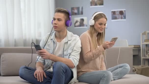 Adolescentes sincronizando sus listas de reproducción, compartiendo sus intereses entre sí — Vídeo de stock