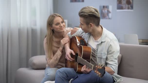 Estudante adolescente tocando música e namorada abraçando-o, amor romântico confissão — Vídeo de Stock