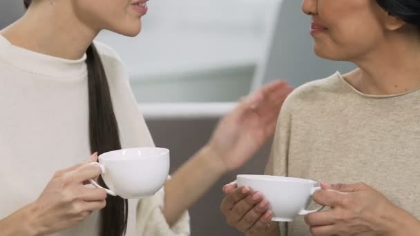 Ενηλίκων αδελφές χαμογελώντας και μιλώντας με τσάι κύπελλα, σπίτι να χαλαρώσουν ατμόσφαιρα, υποστήριξη — Αρχείο Βίντεο