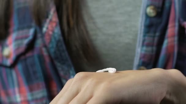 Дама наносить крем на руки, зволожуючи і пом'якшуючи, догляд за шкірою тіла — стокове відео