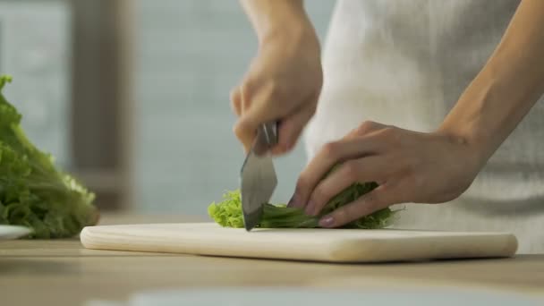 Female hands cutting lettuce on board in kitchen, healthy nutrition, cooking — Stock Video