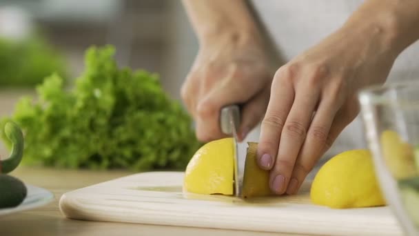 Γυναίκα κοπή λεμόνι και συμπίεση χυμό σε γυάλινο μπολ, σαλάτα λαχανικών — Αρχείο Βίντεο