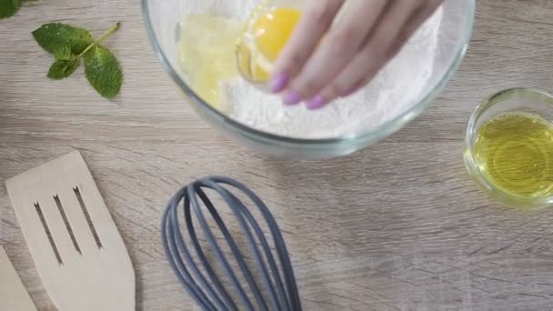 Lady aggiungere l'uovo alla farina e mescolare gli ingredienti con cucchiaio di legno, ricetta torta — Video Stock