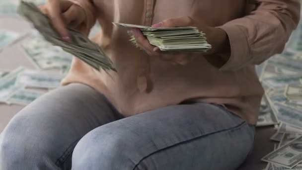 Opgewonden vrouwelijke tellen pack dollars gooien ze omhoog, het winnen van de loterij — Stockvideo