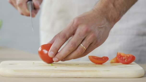 Chef masculino cortar com precisão tomates na cozinha e adicioná-lo ao prato, cozinhar — Vídeo de Stock