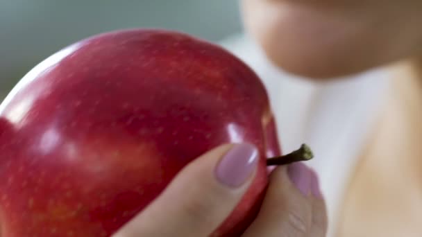Mujer mordiendo manzana roja jugosa por dientes sanos, fuente de vitaminas y calcio — Vídeo de stock