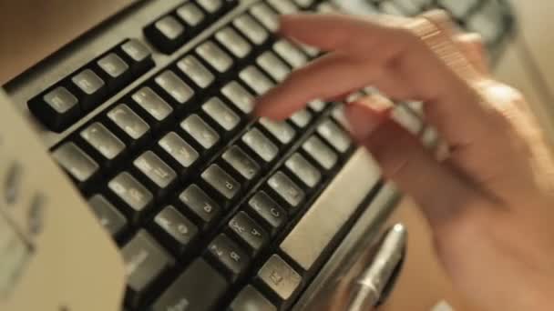 Женщина вручную печатает клавиатуру компьютера, работает в офисе, заполняет электронный отчет — стоковое видео