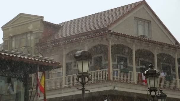 Oude houten gebouw met een lijst van vlaggen van Spanje en Georgië op regenachtige dag, diplomatie — Stockvideo