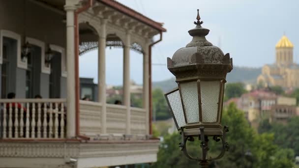Luz de calle antigua cerca del antiguo edificio con terraza abierta, día lluvioso en Tiflis — Vídeos de Stock