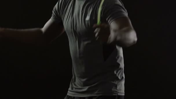Homme énergique se réchauffant avec une corde sautante avant l'entraînement, la force, le ralenti 
