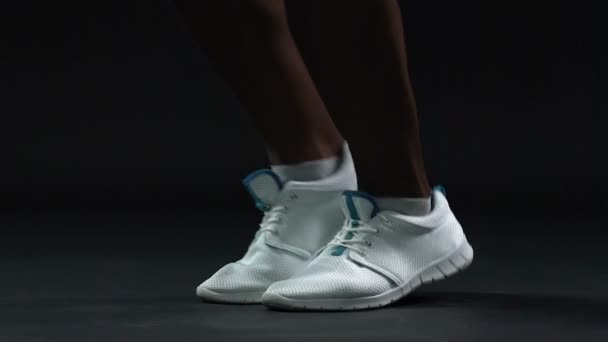 Strong male legs in white sneakers skipping over rope, active lifestyle, slow-mo — Stock Video