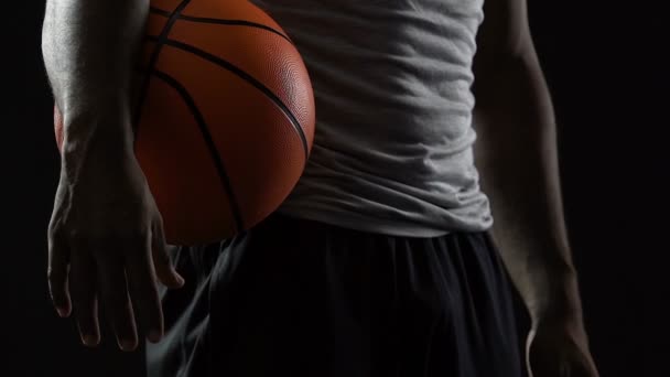 Jogador de basquete experiente em pé com bola nas mãos, homem forte motivado — Vídeo de Stock