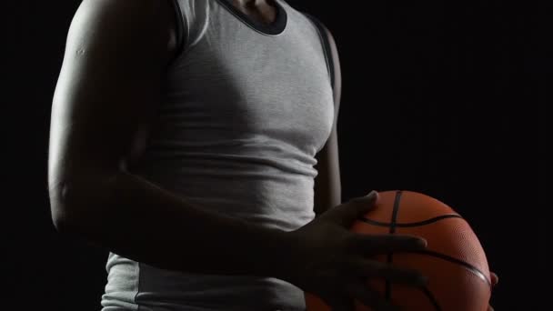 Jugador de baloncesto hábil sosteniendo la pelota en manos musculosas, listo para ganar el partido — Vídeos de Stock