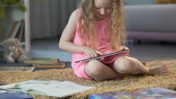 Улыбающийся ребенок смотрит образовательное видео на планшете, используя современные технологии — стоковое видео
