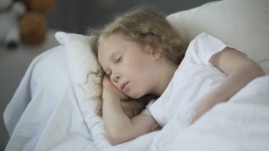 Sarışın küçük kız yatakta rahat evde, iyi bir sağlık için sakin dinlenme uyku