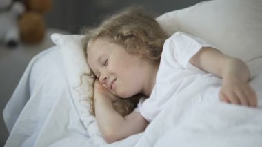Mutlu genç kız iyi zevk sıcak yatakta uyuyor ise gülen çocuk rüyalar.