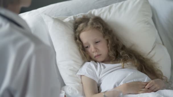 Enfermera ofreciendo pastillas a un niño infeliz con bajo sistema inmunológico, epidemia de gripe — Vídeos de Stock