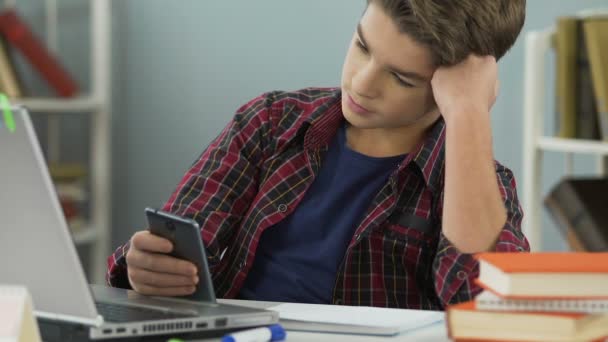 Aluno da escola entediado olhando indiferentemente para os livros de lição de casa, navegar na internet — Vídeo de Stock
