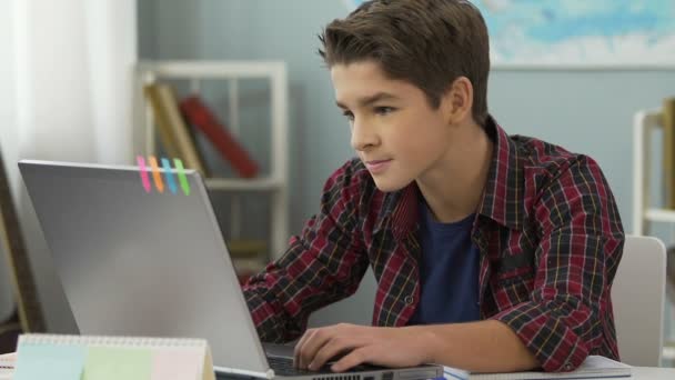 Adolescente haciendo con éxito el trabajo práctico para la lección de programación utilizando el ordenador portátil — Vídeos de Stock