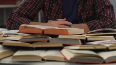 Genç çocuk dolusu okul kitap, hazırlama, ödev masada oturan overworked