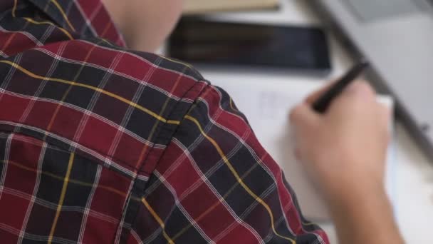 Junge durchstreicht geschriebenen Text im Notizbuch, Hausaufgaben, schwieriges Thema — Stockvideo