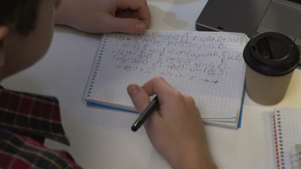 College student rozwiązywania równania matematyczne i picia kawy, pisanie w notesie — Wideo stockowe