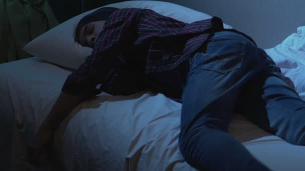 Högskolestudent sover i tyg på sängen efter studentfest, drömmar på natten — Stockvideo