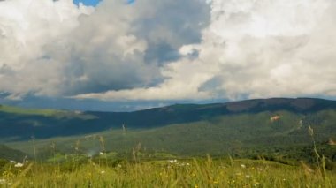Mavi gökyüzü hızlandırılmış yüksek tepe dağlardan çalışan güzel kabarık bulutlar