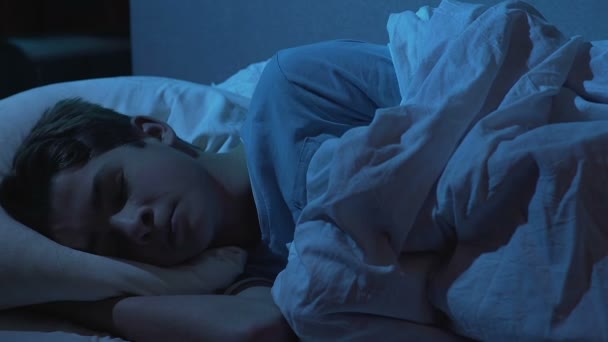 Mãe suavemente acariciando a cabeça do filho adormecido, cobrindo com edredão, cuidados familiares — Vídeo de Stock