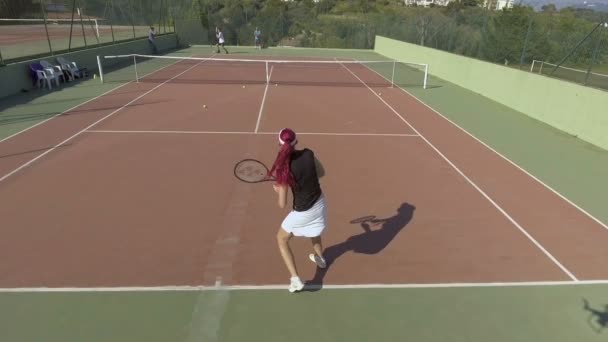 Donna dai capelli rossi che gioca a tennis con il suo ragazzo, vista aerea della corte — Video Stock