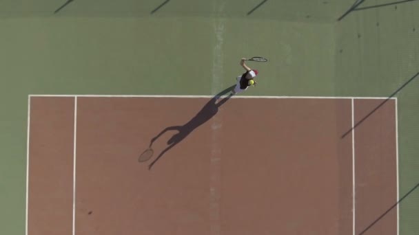 Спортивная женщина в кепке играет в теннис, вид с воздуха на женщин практикующих выстрел — стоковое видео