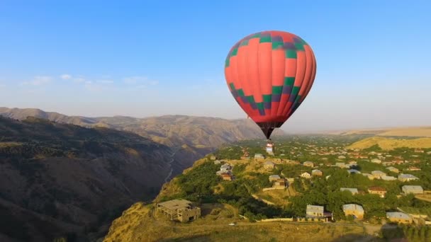 Aerial view of beautiful hot air balloon flying over mountain village, Armenia — Stock Video