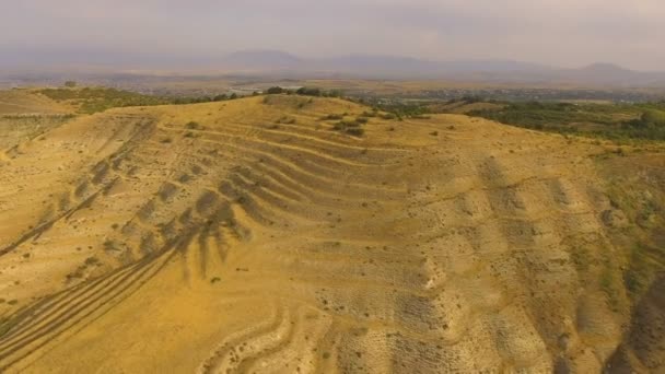 Vista del terreno montañoso arenoso de Armenia, pequeño pueblo en la distancia, Cáucaso — Vídeo de stock