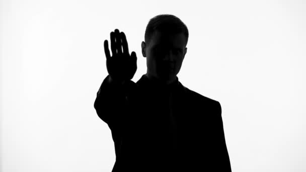 Männersilhouette zeigt Stoppschild mit der Hand, Kampf gegen Korruption und Kriminalität — Stockvideo