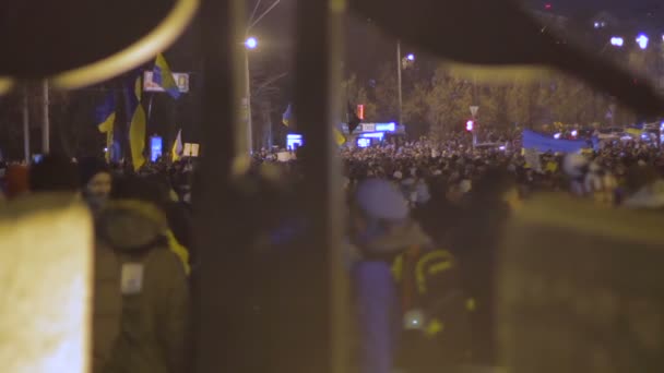 QUIIV, UCRÂNIA - CIRCA DEZEMBRO 2014: manifestações Euromaidan. Close-up de pedra figura religiosa com manifestantes ucranianos em segundo plano — Vídeo de Stock