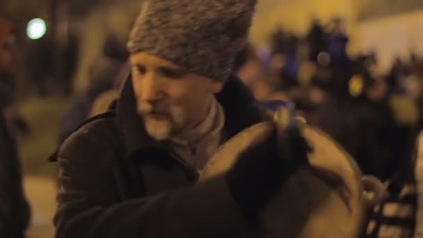 Kiev, Oekraïne - Circa December 2014: Euromaidan demonstraties. Oudere man uitvoeren op etnische muziekinstrument op drukke straat, Kozakken — Stockvideo